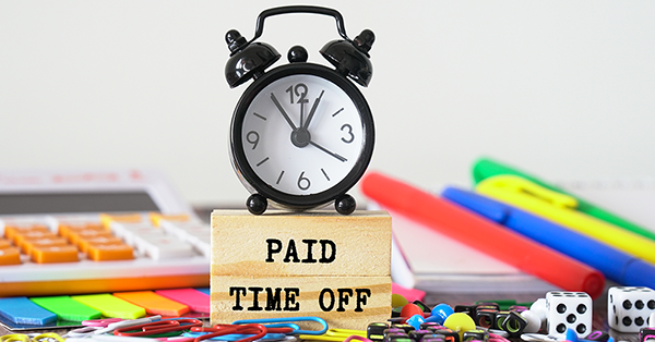 A cluttered desk with an alarm clock on it reads 'Paid time off'. Self Employed Holiday Pay for Newly Classified Workers. A case study from Employment Law Friend A cluttered desk with an alarm clock on it reads 'Paid time off'. Self Employed Holiday Pay for Newly Classified Workers. A case study from Employment Law Friend